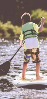 Boy paddleboarding on a calm lake