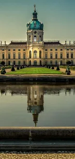 Palace reflected in tranquil pond with lush gardens and clear sky.