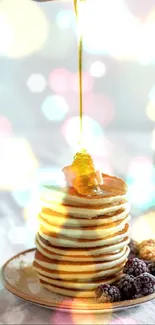 Stacked pancakes with honey and blackberries on a plate.