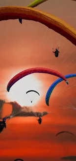 Vibrant paragliders soaring across an orange sunset sky.