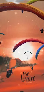 Colorful paragliders soar in an inspiring orange sunset sky.