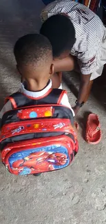 Parent helping child with bright backpack.