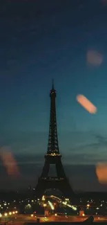 Eiffel Tower with glowing city lights against a deep blue evening sky.