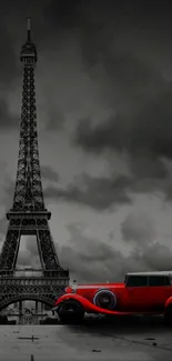 Eiffel Tower with vintage red car in grayscale setting.