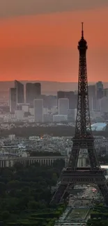 A breathtaking view of the Eiffel Tower at sunset with a vibrant orange sky.