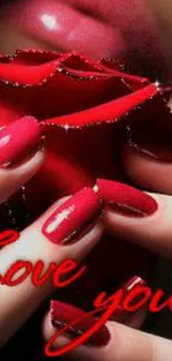 Close-up of vibrant red rose and elegant nails with love inscription.