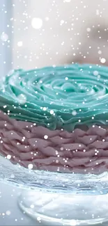 Pastel cake with mint green and pink frosting on a glass stand.