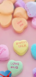 Pastel candy hearts scattered on pink background.