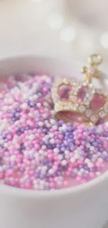 Pastel pink and purple sprinkles with a golden crown in a bowl.