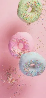 Whimsical pastel donuts with sprinkles on pink background.