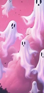 Pastel ghost illustrations floating in pink clouded sky wallpaper.