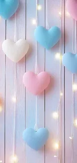 Pastel hearts hanging with twinkling lights on a wall.