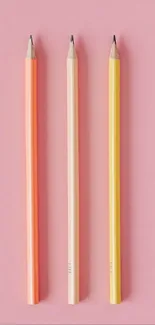 Three colorful pencils on a pink background.