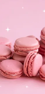 A cluster of pastel pink macarons on a light pink background.