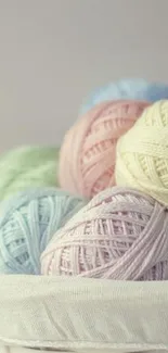 Basket of pastel yarn balls in soft hues.