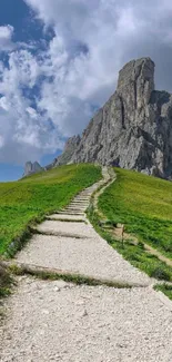 Stone pathway leading to majestic mountain under blue sky.