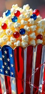 Patriotic popcorn with colorful candy in red and blue stripes container.