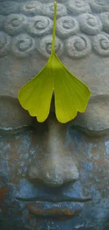 Buddha statue with a green leaf accent on the forehead, exuding tranquility.