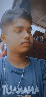 Young man sits peacefully on a bus, capturing a serene travel moment.