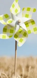 Green and white pinwheel in wheat field.