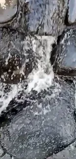 Flowing stream over dark rocks wallpaper