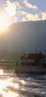 Boats on a serene lake at sunset with mountains in the background.