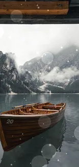 Wooden boat on tranquil mountain lake with misty mountains in the background.