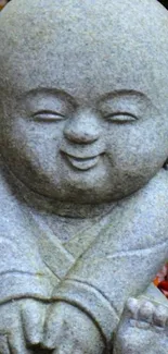 Stone monk statue with autumn leaves around.