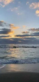 Beautiful sunset over a calm ocean with gentle waves and a glowing sky.