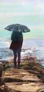 Person with umbrella on rocky shore, facing calm ocean.