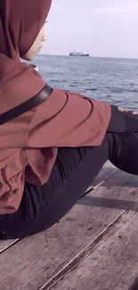 Person sitting by the ocean on a peaceful day.