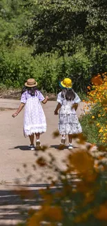 Two children walk down a flower-lined path in a lush green landscape.