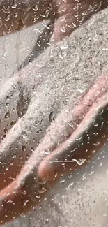 Artistic hands holding sand with water drops on a phone wallpaper.