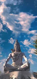 Peaceful statue of Shiva meditating under a blue sky with clouds.