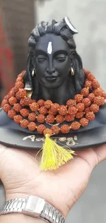 Shiva sculpture with rudraksha beads in hand.