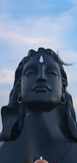 Peaceful Shiva statue with clear sky background.