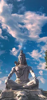 Serene Shiva statue beneath a vibrant blue sky with white clouds.