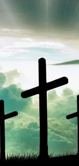 Silhouetted crosses against a serene sky with clouds.