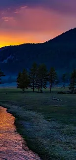 Sunset over green mountains and river with vibrant sky colors.