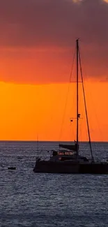 Sunset sky with sailboat on ocean horizon, vibrant orange hues.