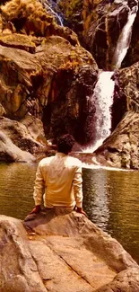 Traveler sits by serene waterfall.