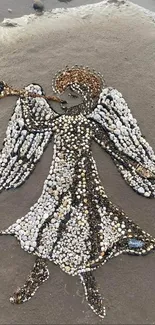 Angel made of pebbles on sandy beach creating stunning natural art.