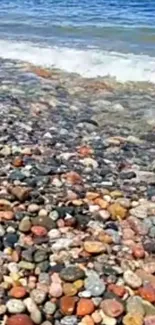 Colorful pebble beach with ocean waves.