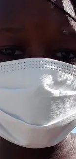 Close-up portrait of person wearing a face mask outdoors.