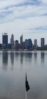 Perth city skyline with waterfront reflection under cloudy sky.