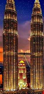 Petronas Towers illuminated against starry night sky.