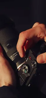 Close-up of hands adjusting a camera lens.