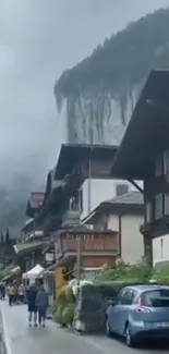 Charming village against a misty cliff backdrop.