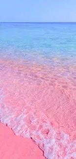 Pink sand beach with blue sea waves in vibrant phone wallpaper.