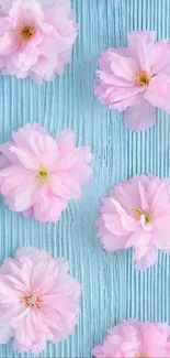 Mobile wallpaper with pink blossoms on blue textured background.